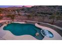 Aerial view of a freeform pool and spa with a mountain backdrop at 16439 E Nicklaus Dr, Fountain Hills, AZ 85268