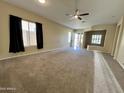 Spacious living room with neutral carpeting and large windows at 17597 W Aster Dr, Surprise, AZ 85388