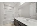 A well lit bathroom with vanity sink, large mirror, and a shower-tub combo at 17638 W Rancho Dr, Litchfield Park, AZ 85340