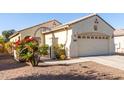 House exterior view with a two-car garage and lush landscaping at 20518 N 261St Ave, Buckeye, AZ 85396