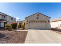 House exterior showcasing a two-car garage and desert landscaping at 20518 N 261St Ave, Buckeye, AZ 85396