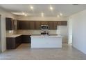 Modern kitchen with dark brown cabinets and a large island at 20811 N 223Rd Ave, Surprise, AZ 85387