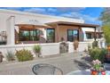 Relaxing front patio with umbrella, small table, and desert landscaping at 221 E Nebraska St, Florence, AZ 85132