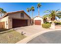 Two-car garage home with a tan exterior and desert landscaping at 25046 S Foxglenn Dr, Sun Lakes, AZ 85248