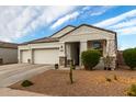 Two-car garage, stone accents, and nicely landscaped front yard at 3224 N Lainey Ln, Buckeye, AZ 85396