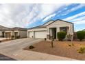 White stucco home with a two-car garage and desert landscaping at 3224 N Lainey Ln, Buckeye, AZ 85396