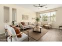 Bright and airy living room with stylish furniture, wood-look floors, and a large window, complete with a ceiling fan at 4229 E Crest Ct, Gilbert, AZ 85298