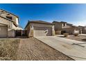 Tan house with tile roof, two-car garage, and desert landscaping at 42788 W Martie Lynn Rd, Maricopa, AZ 85138