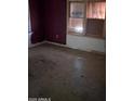 A bedroom in disrepair with a worn floor and damaged walls, with an aged window adding to the room's state at 504 W Baseline Rd, Buckeye, AZ 85326