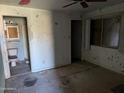Image shows a bedroom with peeling paint, damaged walls, and a deteriorated bathroom to the side at 504 W Baseline Rd, Buckeye, AZ 85326