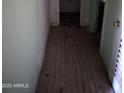 This hallway features damaged flooring and weathered walls, indicating it needs significant repair and renovation at 504 W Baseline Rd, Buckeye, AZ 85326