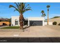 Single story home with gray garage door and landscaped front yard at 7730 E Buena Terra Way, Scottsdale, AZ 85250