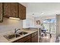 Kitchen with light wood cabinets, double sink, and view into dining area at 8131 N 107Th Ave # 81, Peoria, AZ 85345