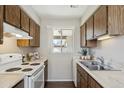 Cozy kitchen featuring wood cabinets, white appliances, and a window at 8131 N 107Th Ave # 81, Peoria, AZ 85345