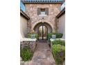 Charming entryway with stone details and arched doorway at 9111 E Mountain Spring Rd, Scottsdale, AZ 85255