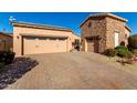 Two-car garage with paver driveway and stucco exterior house at 17770 W Cottonwood Ln, Goodyear, AZ 85338
