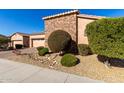 House exterior with stone accents, lush landscaping, and a two-car garage at 17770 W Cottonwood Ln, Goodyear, AZ 85338