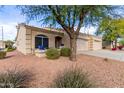Tan stucco house with two-car garage and mature tree at 2101 S Yellow Wood -- # 75, Mesa, AZ 85209