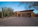 Tan two-car garage and paver driveway are featured in this home exterior at 29991 N 78Th Pl, Scottsdale, AZ 85266