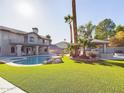 Large backyard with pool, covered patio, and lush landscaping at 4530 W Misty Willow Ln, Glendale, AZ 85310