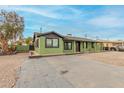 Exterior view of the home featuring a paved driveway and green facade at 4602 N 47Th Ave, Phoenix, AZ 85031