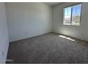 Bright bedroom featuring plush carpeting and a window letting in ample natural light at 47250 W Mellen Ln, Maricopa, AZ 85139