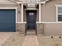 Close up of the front door, featuring a black front door and brick walkway and pillars at 4816 N 177Th Ln, Goodyear, AZ 85395