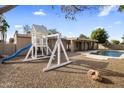 Large backyard with a sparkling pool, playground, and plenty of space for entertaining at 7618 E Ironwood Dr, Scottsdale, AZ 85258