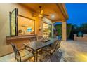 Covered outdoor dining area featuring a sleek table set and pass through window to kitchen at 1397 E Verde Blvd, Queen Creek, AZ 85140