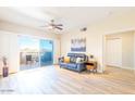 Open living area with hardwood floors, sliding glass doors to a balcony, and a leather couch at 14950 W Mountain View Blvd # 2301, Surprise, AZ 85374