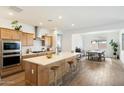 Modern kitchen with light wood cabinets, island, and stainless steel appliances at 16780 W Cameron Dr, Surprise, AZ 85388