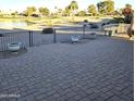 Brick paved patio overlooks a lake and golf course at 26409 S Moonshadow Dr, Sun Lakes, AZ 85248