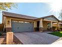 House exterior featuring a gray garage door and artificial turf at 2707 N Acacia Way, Buckeye, AZ 85396