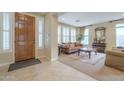 Living room with tiled floors, wooden furniture, and large windows at 3151 E Turnberry Dr, Gilbert, AZ 85298