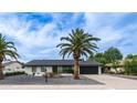Charming single-story home featuring desert landscaping and a black garage door with a clear blue sky overhead at 4916 E Kathleen Rd, Scottsdale, AZ 85254