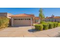 Tan house with a two-car garage and well-manicured hedges at 6425 N 79Th St, Scottsdale, AZ 85250