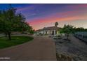 House exterior view at dusk, showcasing a circular driveway and landscaping at 715 S Cactus Wren St, Gilbert, AZ 85296