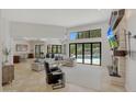 Open concept living space with a fireplace and large windows at 7347 E Turquoise Ave, Scottsdale, AZ 85258