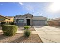 Single story home with gray siding, stone accents, and a two car garage at 7917 W Sierra Vista Dr, Glendale, AZ 85303