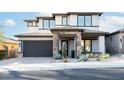 Two-story home with stone accents, a three-car garage, and desert landscaping at 10018 E Hillside Dr, Scottsdale, AZ 85255