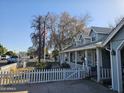 Gray house exterior with a white picket fence and American flag at 1041 E 9Th Dr, Mesa, AZ 85204