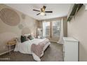 Cozy bedroom with unique wall art and ample natural light at 10538 E Sheffield Dr, Mesa, AZ 85212