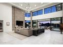 Open-concept living room with a fireplace and access to the outdoor patio at 10944 E Whistling Wind Way, Scottsdale, AZ 85255