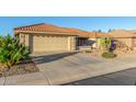 House exterior showcasing a tan stucco finish, tile roof, and desert landscaping at 2144 S Yellow Wood Ave, Mesa, AZ 85209