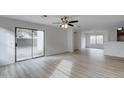 Bright living room with sliding glass doors and laminate wood flooring at 33868 N Mercedes Dr, San Tan Valley, AZ 85144