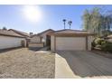 Front view of a tan house with a two-car garage and desert landscaping at 4149 W Park Ave, Chandler, AZ 85226