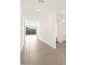 Bright hallway with tile flooring leading to sliding glass doors and a bathroom at 4847 W Hunter Trl, San Tan Valley, AZ 85144