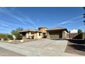 Tan colored house with a three-car garage and RV gate at 4905 W Magellan Dr, New River, AZ 85087