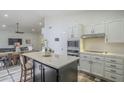 Modern kitchen with white cabinets, quartz countertops, and a large island at 605 S 30Th Cir, Mesa, AZ 85204