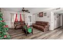 Living room with brown leather couches and wood floors at 7135 W Heatherbrae Dr, Phoenix, AZ 85033